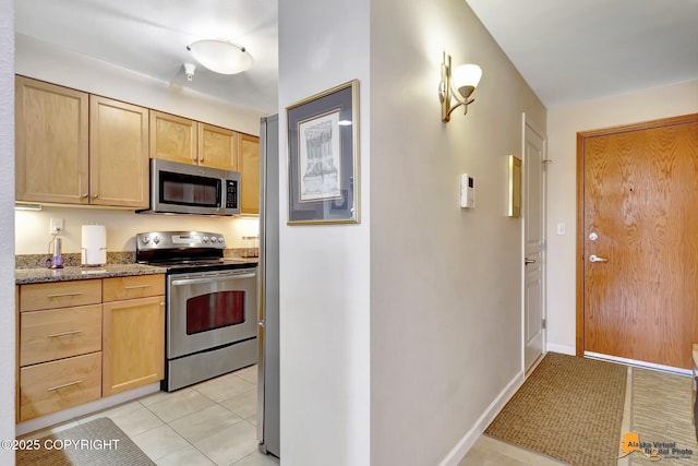 1200 I St Unit 314, Anchorage, AK 99501 - kitchen with appliances with stainless steel finishes, light brown cabinetry, light stone counters, and light tile patterned floors