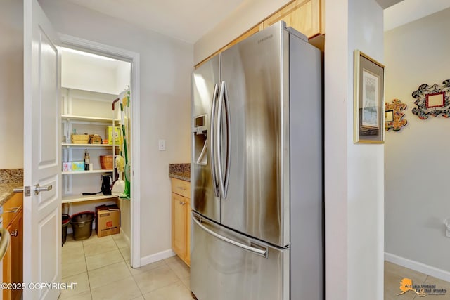 1200 I St Unit 314, Anchorage, AK 99501 - kitchen with stainless steel fridge with ice dispenser, light tile patterned floors, light stone counters, and light brown cabinets
