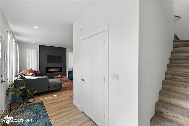220 Susieana Ln, Kenai, AK 99611 - staircase featuring wood finished floors, a fireplace, and recessed lighting