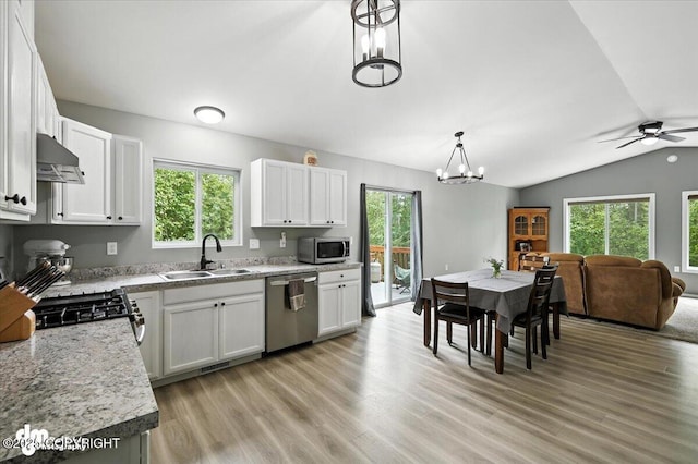 2660 N Jasper Dr, Wasilla, AK 99654 - kitchen featuring appliances with stainless steel finishes, under cabinet range hood, white cabinets, light wood finished floors, and lofted ceiling