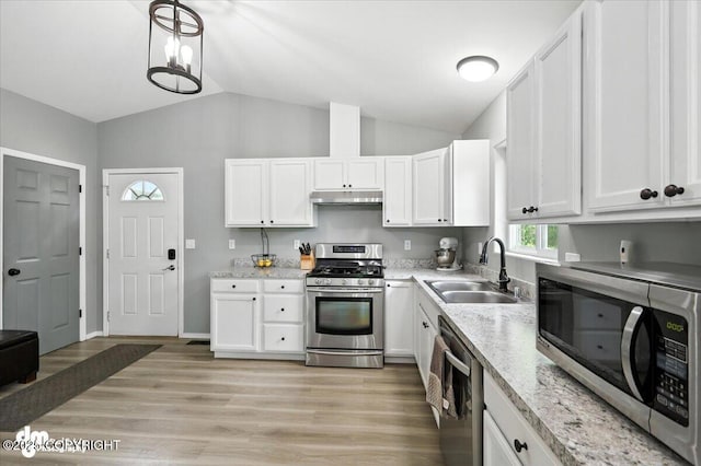 2660 N Jasper Dr, Wasilla, AK 99654 - kitchen with stainless steel appliances, lofted ceiling, white cabinetry, under cabinet range hood, and light wood-style floors