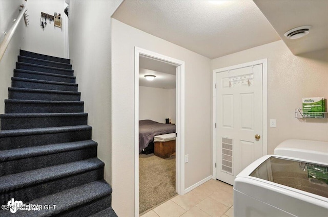 2660 N Jasper Dr, Wasilla, AK 99654 - washroom with light tile patterned floors, separate washer and dryer, and a textured ceiling