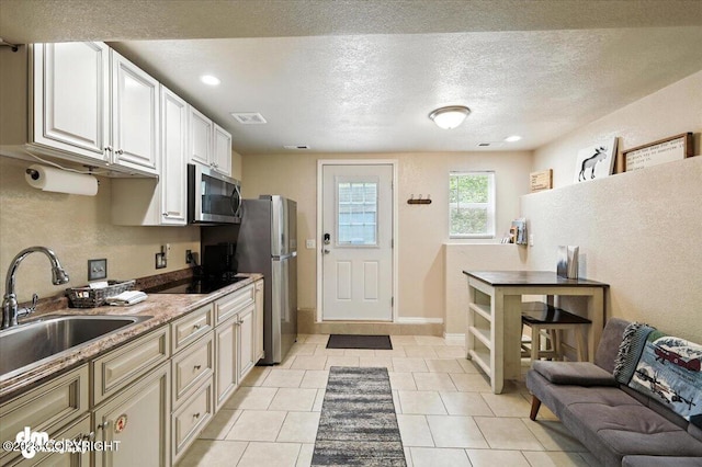 2660 N Jasper Dr, Wasilla, AK 99654 - kitchen featuring stainless steel appliances, a textured ceiling, and light tile patterned floors