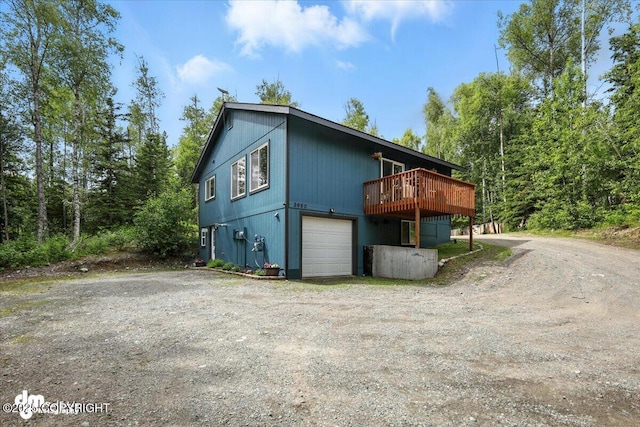 2660 N Jasper Dr, Wasilla, AK 99654 - view of home's exterior with dirt driveway, a deck, and a garage