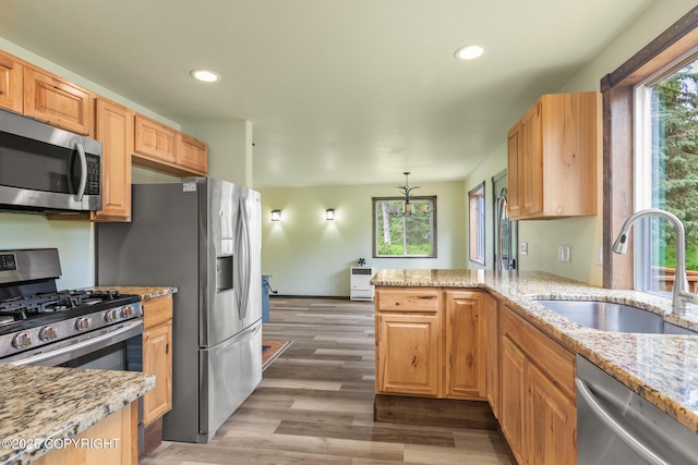 47459 Lakeside St, Nikiski/North Kenai, AK 99611 - kitchen featuring appliances with stainless steel finishes, wood finished floors, light stone counters, recessed lighting, and a peninsula