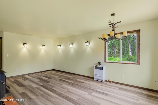 47459 Lakeside St, Nikiski/North Kenai, AK 99611 - unfurnished living room with a chandelier, heating unit, and light wood-type flooring