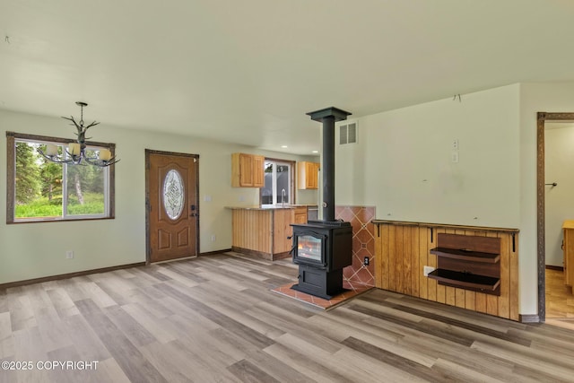 47459 Lakeside St, Nikiski/North Kenai, AK 99611 - unfurnished living room with light wood finished floors, a wood stove, a chandelier, and recessed lighting