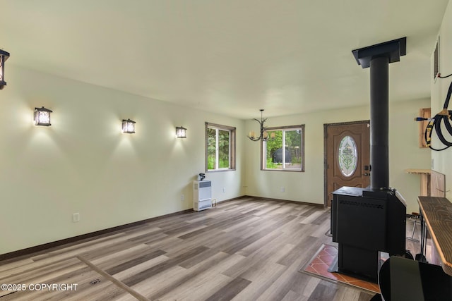 47459 Lakeside St, Nikiski/North Kenai, AK 99611 - living area featuring a wood stove, light wood-style flooring, and a chandelier