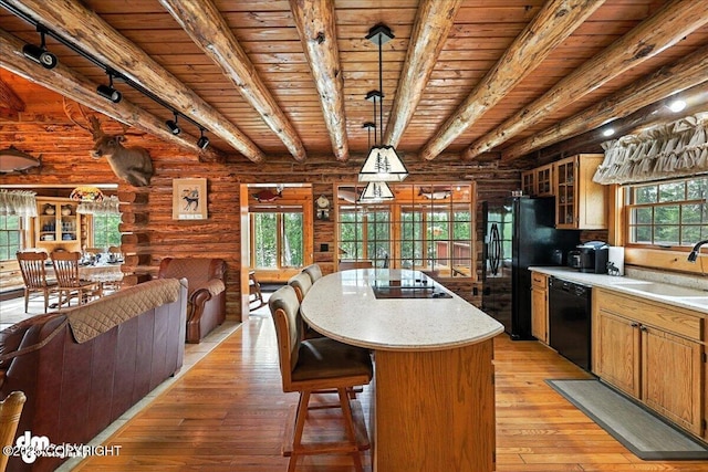 34035 Keystone Dr, Soldotna, AK 99669 - kitchen with black appliances, a wood ceiling with exposed beams, log walls, a kitchen island, and rail lighting