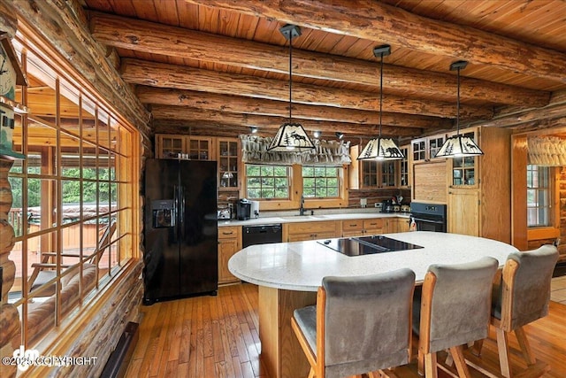 34035 Keystone Dr, Soldotna, AK 99669 - kitchen featuring black appliances, hardwood / wood-style flooring, glass insert cabinets, a center island, and hanging light fixtures