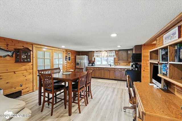 34035 Keystone Dr, Soldotna, AK 99669 - dining room with wooden walls, a textured ceiling, light wood-style floors, and recessed lighting