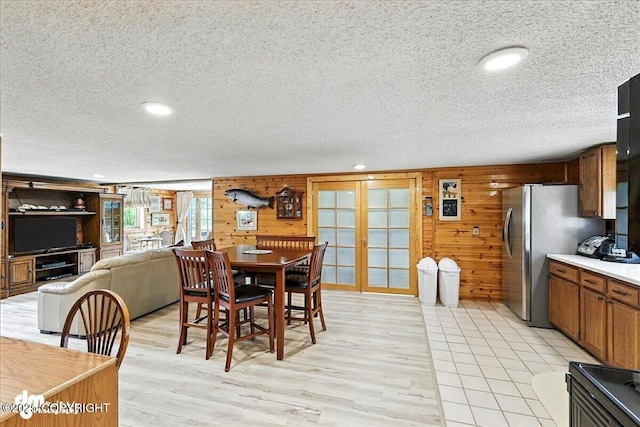 34035 Keystone Dr, Soldotna, AK 99669 - dining area with a textured ceiling, light wood-style floors, french doors, wood walls, and recessed lighting