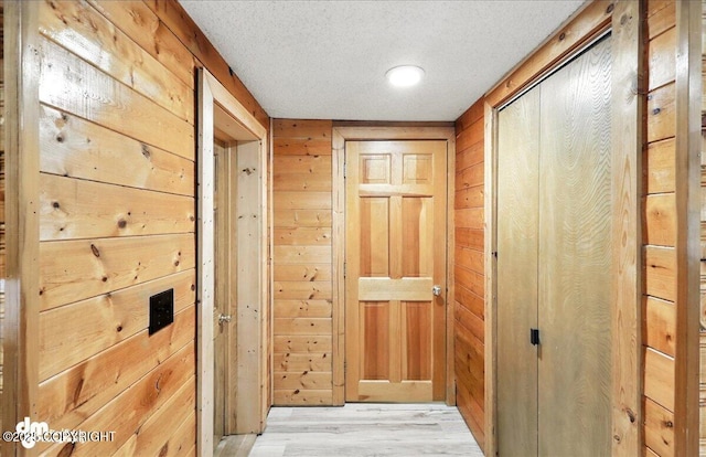 34035 Keystone Dr, Soldotna, AK 99669 - hall with wood walls, light wood-style floors, and a textured ceiling