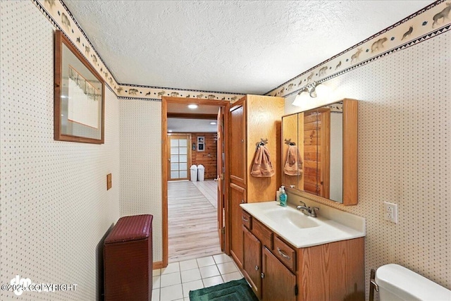 34035 Keystone Dr, Soldotna, AK 99669 - half bath with a textured ceiling, vanity, wallpapered walls, and tile patterned flooring