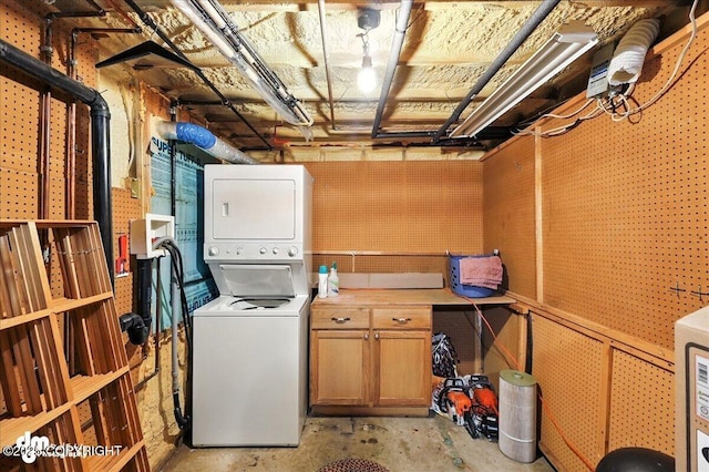34035 Keystone Dr, Soldotna, AK 99669 - washroom featuring stacked washer / dryer and cabinet space