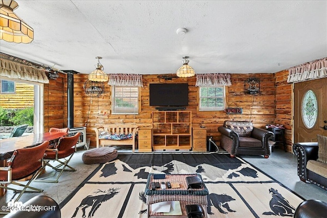 34035 Keystone Dr, Soldotna, AK 99669 - living area with rustic walls, a wood stove, and a textured ceiling