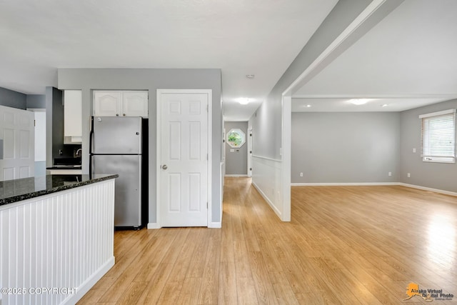 2701 Kempton Hills Dr, Anchorage, AK 99516 - kitchen with freestanding refrigerator, white cabinets, light wood-type flooring, dark stone countertops, and open floor plan