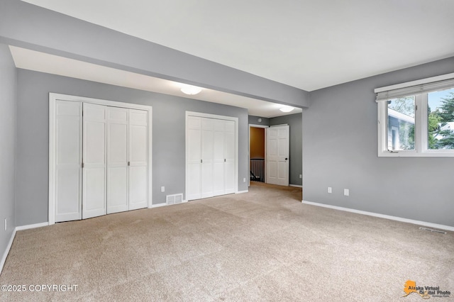 2701 Kempton Hills Dr, Anchorage, AK 99516 - unfurnished bedroom featuring two closets and carpet flooring
