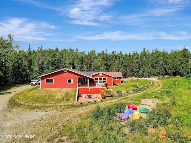 23324 Greatland Dr, Chugiak, AK 99577 - view of front of home featuring driveway, a forest view, and a deck