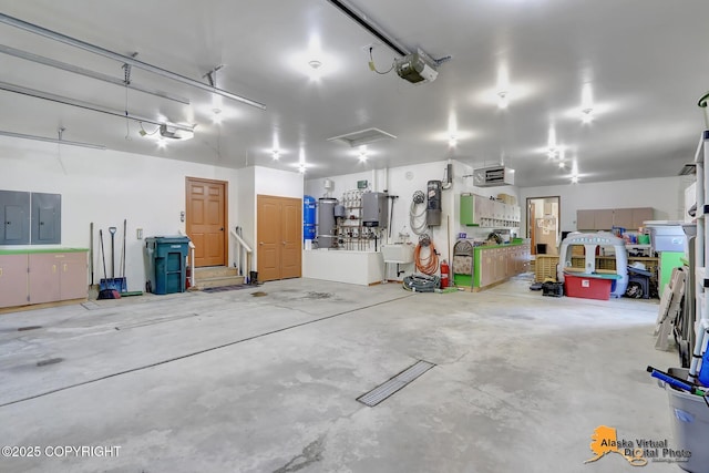 23324 Greatland Dr, Chugiak, AK 99577 - garage with electric panel, a garage door opener, and water heater