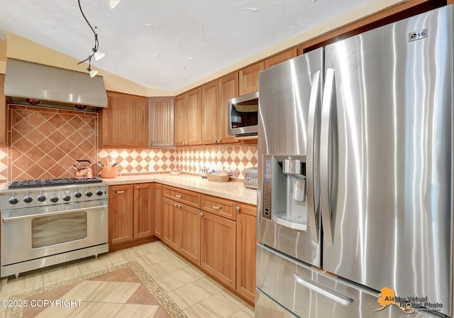23324 Greatland Dr, Chugiak, AK 99577 - kitchen with stainless steel appliances, light tile patterned flooring, island exhaust hood, and decorative backsplash