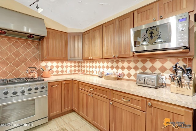 23324 Greatland Dr, Chugiak, AK 99577 - kitchen with stainless steel appliances, range hood, tasteful backsplash, and light tile patterned flooring