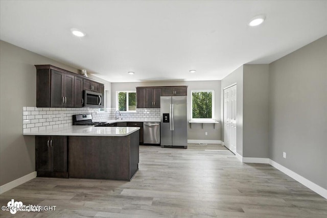 2740 S Rue De La Paix Loop, Wasilla, AK 99623 - kitchen with appliances with stainless steel finishes, dark brown cabinets, a peninsula, backsplash, and recessed lighting
