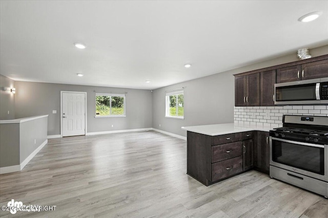2740 S Rue De La Paix Loop, Wasilla, AK 99623 - kitchen featuring stainless steel appliances, dark brown cabinetry, a peninsula, light wood-style flooring, and recessed lighting
