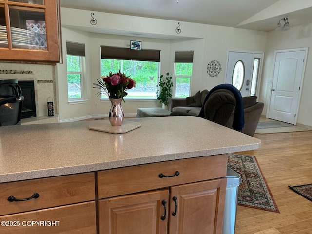 19343 Alma Ave, Chugiak, AK 99567 - kitchen featuring plenty of natural light, light countertops, vaulted ceiling, and a tile fireplace