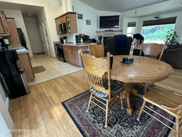 19343 Alma Ave, Chugiak, AK 99567 - dining room featuring vaulted ceiling, light wood-style flooring, and a fireplace