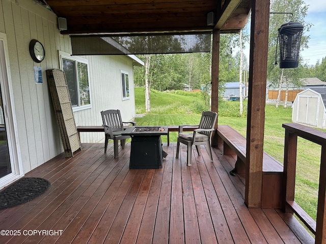19343 Alma Ave, Chugiak, AK 99567 - wooden terrace featuring a fire pit, a lawn, and a storage unit
