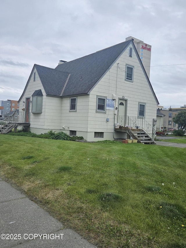 811 K St, Anchorage, AK 99501 - view of home's exterior with roof with shingles, a chimney, and a lawn