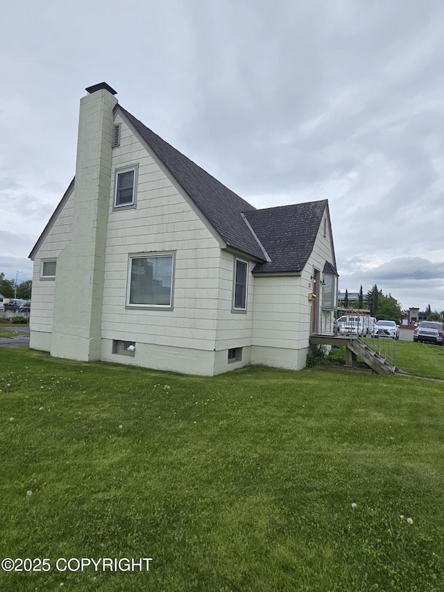 811 K St, Anchorage, AK 99501 - view of property exterior featuring roof with shingles, a chimney, and a lawn