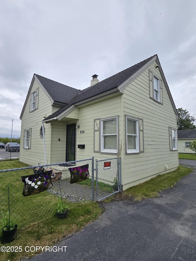 811 K St, Anchorage, AK 99501 - view of front of home featuring a chimney, a gate, and roof with shingles