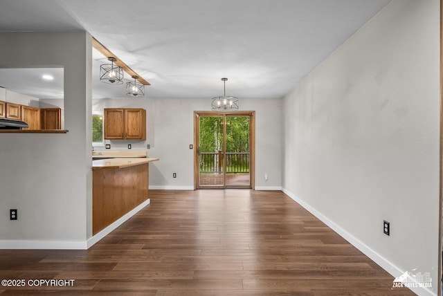 645 W Sarahs Way, Wasilla, AK 99654 - kitchen with exhaust hood, a chandelier, brown cabinets, and dark wood-style floors