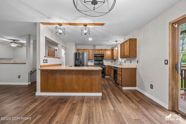645 W Sarahs Way, Wasilla, AK 99654 - kitchen featuring stainless steel appliances, brown cabinets, a peninsula, and dark wood-type flooring