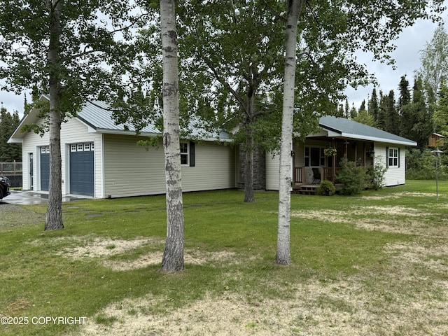 39740 Billikin St, Sterling, AK 99672 - view of front of house featuring a front lawn, a garage, a metal roof, and a porch