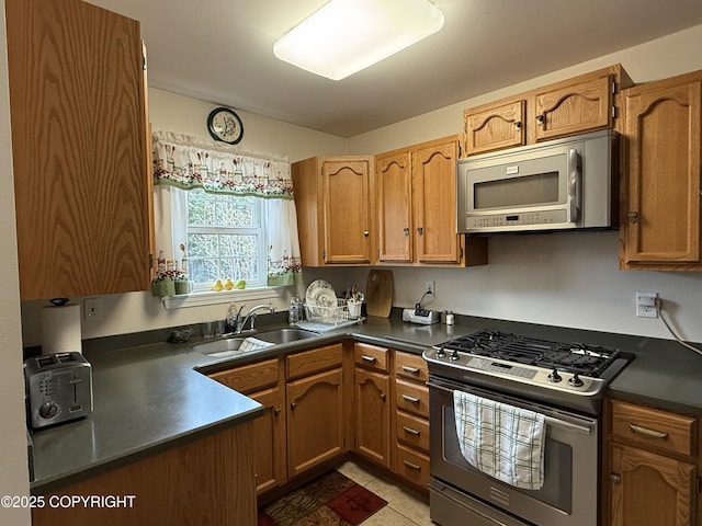 39740 Billikin St, Sterling, AK 99672 - kitchen featuring stainless steel appliances, dark countertops, and brown cabinets