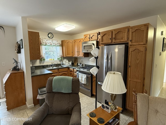 39740 Billikin St, Sterling, AK 99672 - kitchen featuring appliances with stainless steel finishes, dark countertops, light tile patterned floors, and brown cabinetry
