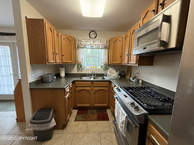 39740 Billikin St, Sterling, AK 99672 - kitchen featuring stainless steel appliances, dark countertops, and brown cabinets