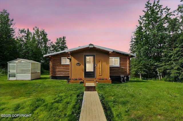 48416 Bernice Lake Rd, Nikiski/North Kenai, AK 99611 - cabin with log siding, a front lawn, an outbuilding, and a greenhouse