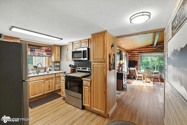48416 Bernice Lake Rd, Nikiski/North Kenai, AK 99611 - kitchen featuring appliances with stainless steel finishes, light wood-style floors, log walls, light countertops, and lofted ceiling