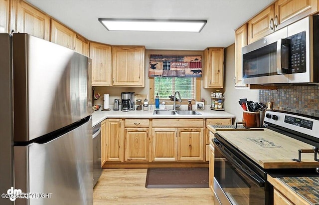 48416 Bernice Lake Rd, Nikiski/North Kenai, AK 99611 - kitchen with stainless steel appliances, light wood finished floors, light brown cabinetry, light countertops, and tasteful backsplash