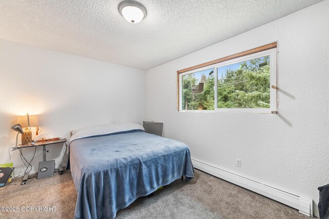 8764 Trinity Dr, Juneau, AK 99801 - carpeted bedroom featuring a baseboard heating unit and a textured ceiling