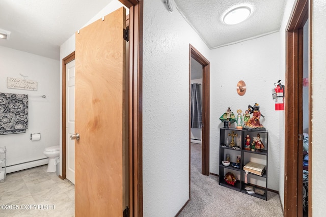 8764 Trinity Dr, Juneau, AK 99801 - corridor with baseboard heating, a textured wall, and a textured ceiling
