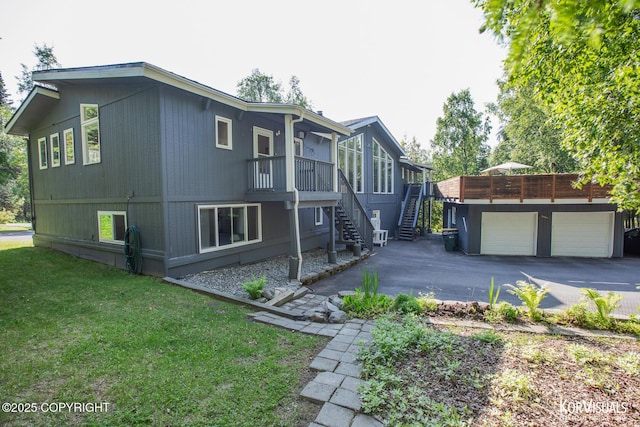 4450 Trapline Dr, Anchorage, AK 99516 - view of side of home featuring stairs, a garage, a lawn, a deck, and driveway