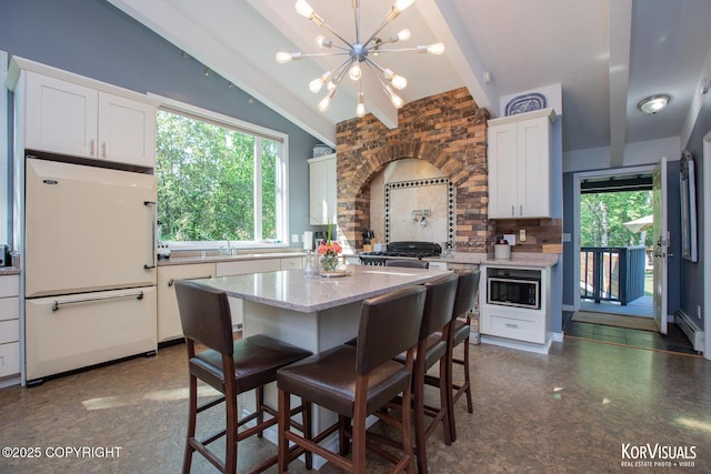4450 Trapline Dr, Anchorage, AK 99516 - kitchen featuring white refrigerator, stainless steel microwave, backsplash, and white cabinetry
