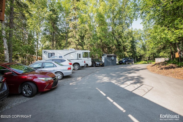 4450 Trapline Dr, Anchorage, AK 99516 - uncovered parking lot with view of wooded area