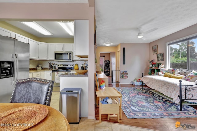 1124 Fred Cir, Anchorage, AK 99515 - kitchen with appliances with stainless steel finishes, decorative backsplash, white cabinets, and a ceiling fan