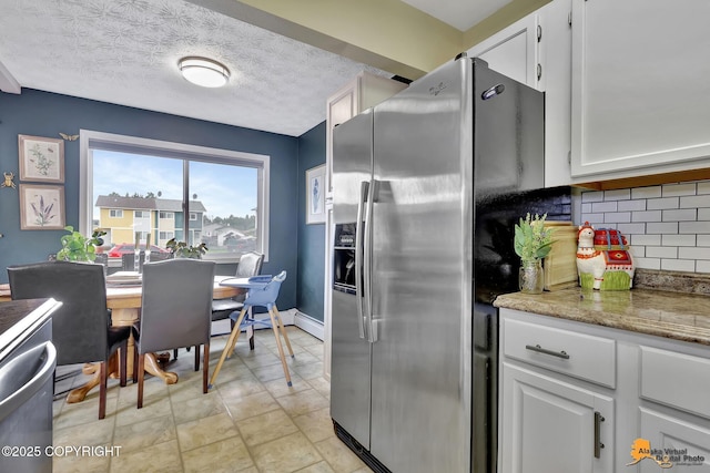 1124 Fred Cir, Anchorage, AK 99515 - kitchen featuring appliances with stainless steel finishes, tasteful backsplash, white cabinets, a textured ceiling, and light stone countertops